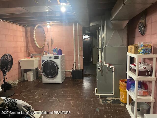 6422 E Saginaw Hwy, Grand Ledge, MI 48837 - clothes washing area with washer / clothes dryer, heating unit, dark flooring, and concrete block wall