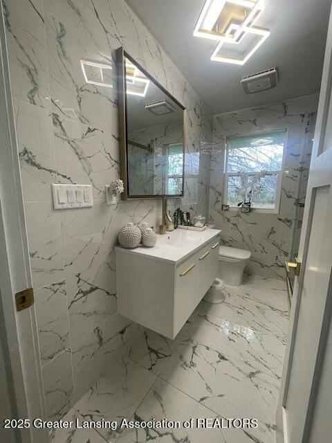 6422 E Saginaw Hwy, Grand Ledge, MI 48837 - bathroom featuring toilet, vanity, healthy amount of natural light, and marble finish flooring