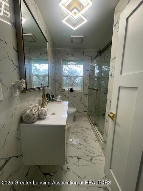 6422 E Saginaw Hwy, Grand Ledge, MI 48837 - bathroom featuring toilet, a marble finish shower, vanity, and marble finish floors