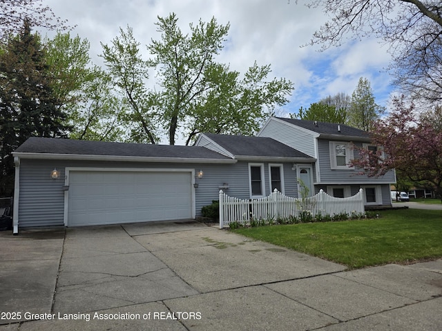 tri-level home with an attached garage and concrete driveway