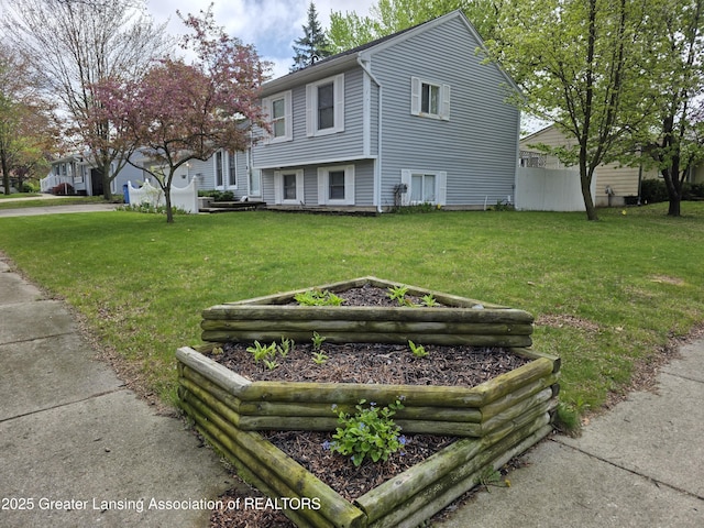 view of side of home with a garden and a lawn
