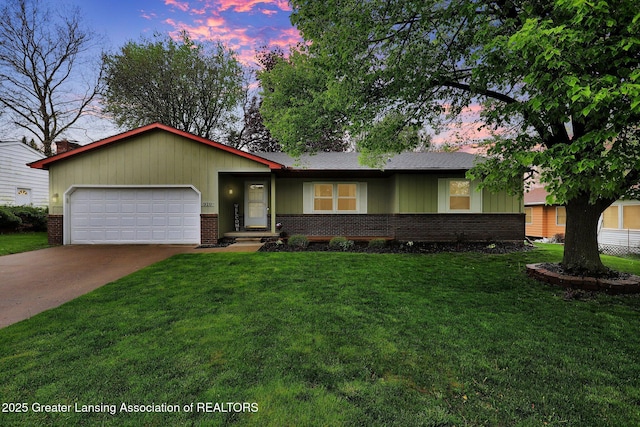 910 Pecos Dr, Lansing, MI 48917 - ranch-style house featuring brick siding, a garage, driveway, and a front yard