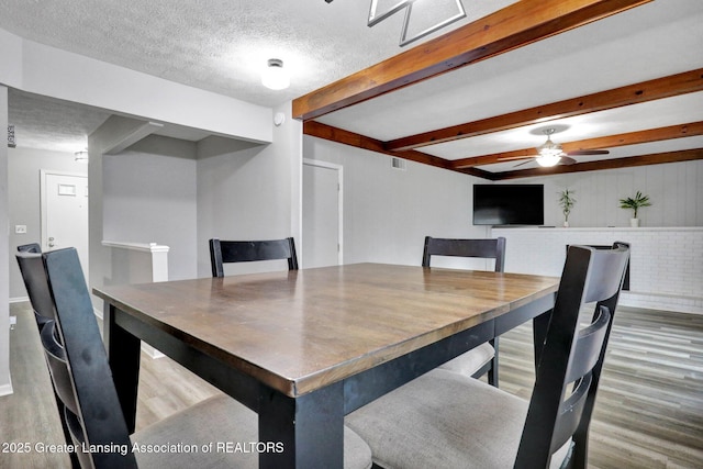 910 Pecos Dr, Lansing, MI 48917 - dining space with wood finished floors, ceiling fan, beamed ceiling, and a textured ceiling