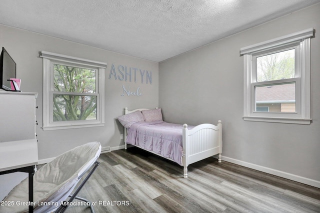910 Pecos Dr, Lansing, MI 48917 - bedroom with wood finished floors, a textured ceiling, and baseboards