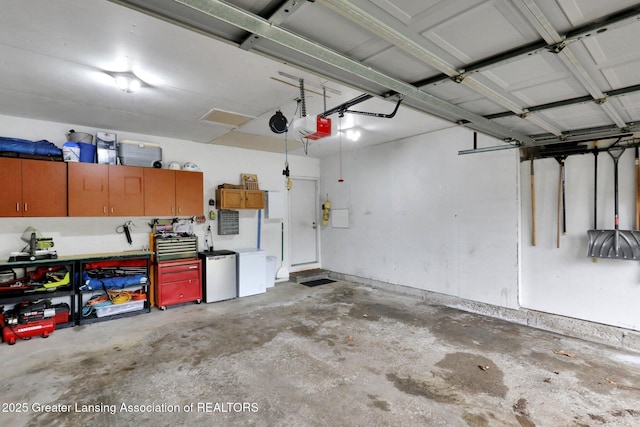 910 Pecos Dr, Lansing, MI 48917 - garage featuring a garage door opener and fridge
