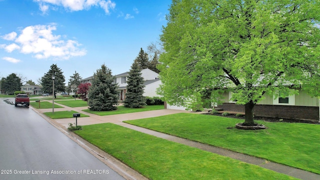 910 Pecos Dr, Lansing, MI 48917 - view of front of property featuring a front lawn, driveway, brick siding, and a garage
