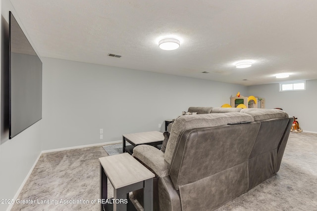 home theater room featuring light carpet, a textured ceiling, and baseboards