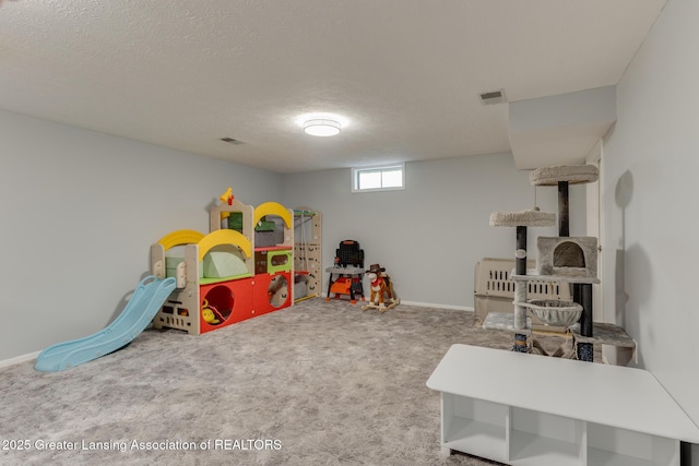 rec room featuring carpet floors and a textured ceiling