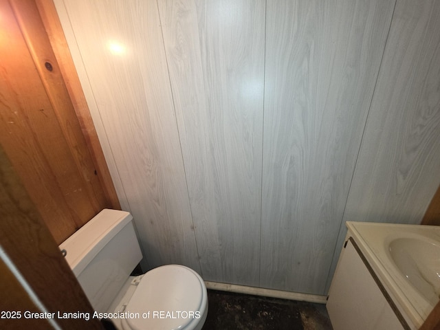 526 Fenton St, Lansing, MI 48910 - half bath featuring vanity, toilet, and wooden walls