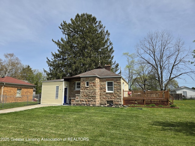 view of front of house featuring stone siding, a chimney, and a deck
