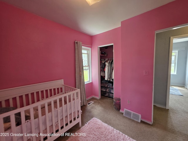 carpeted bedroom featuring baseboards and a closet