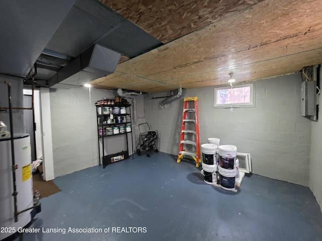 below grade area with water heater, electric panel, and concrete block wall