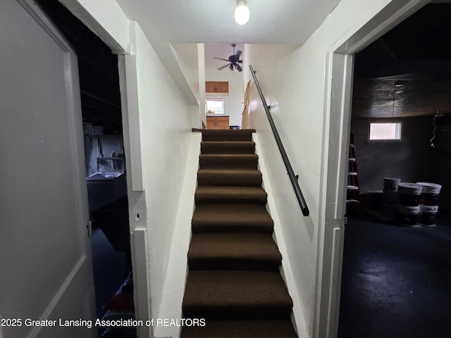 stairway with a ceiling fan