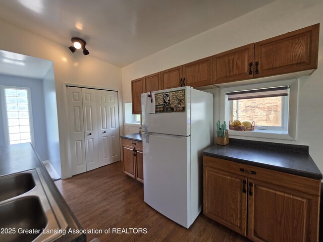 kitchen featuring freestanding refrigerator, dark countertops, and dark wood-style floors