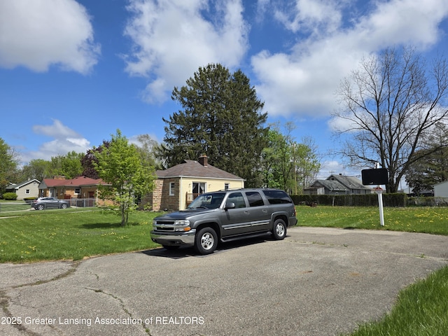 view of front of home with a front lawn, a chimney, and a residential view