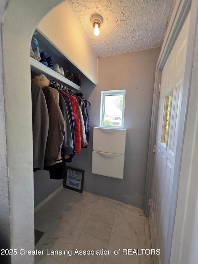 spacious closet with marble look tile flooring