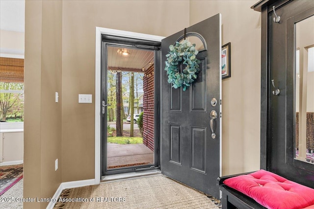 carpeted entrance foyer featuring baseboards