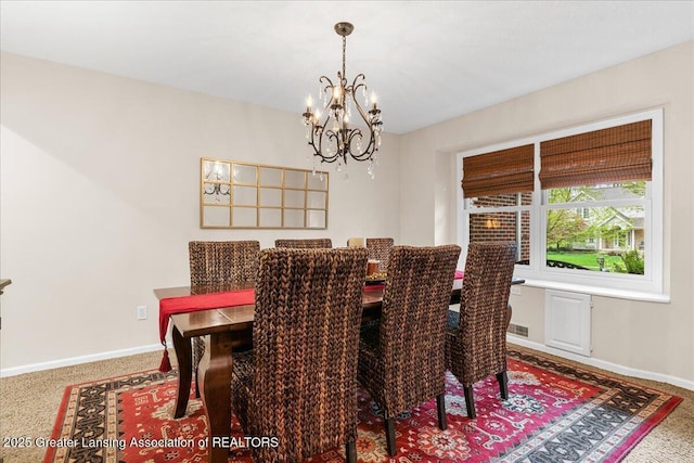 carpeted dining space with a chandelier and baseboards