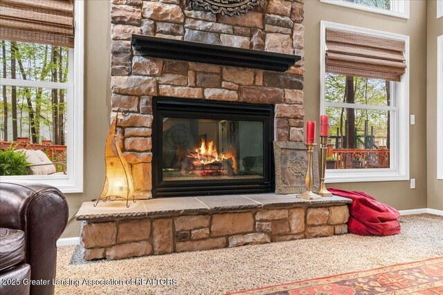 detailed view of baseboards, a fireplace, and carpet floors