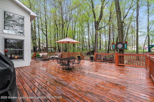 deck with outdoor dining space and a grill