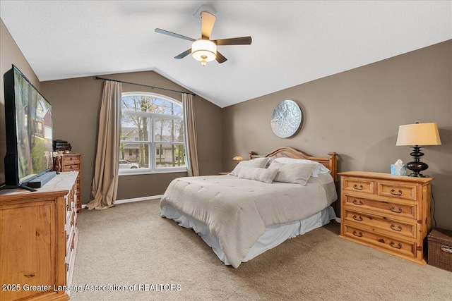bedroom with vaulted ceiling, light carpet, and a ceiling fan