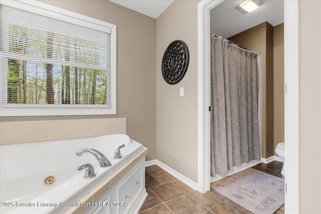 bathroom with baseboards, tile patterned flooring, a bath, a shower with curtain, and toilet