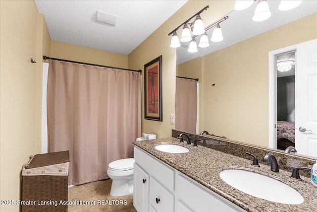 bathroom with toilet, double vanity, and a shower with shower curtain