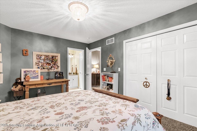 bedroom with a closet, carpet floors, ensuite bathroom, and a textured ceiling