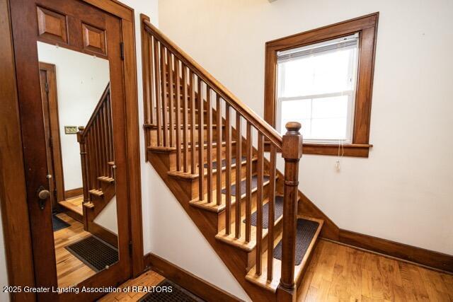 staircase featuring baseboards and wood finished floors