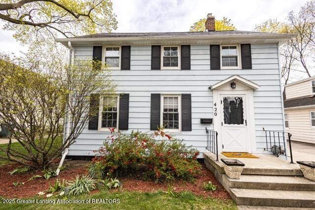 colonial-style house featuring a chimney