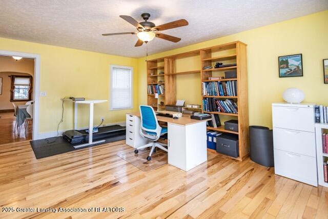 office space with wood finished floors, a ceiling fan, a textured ceiling, and baseboards