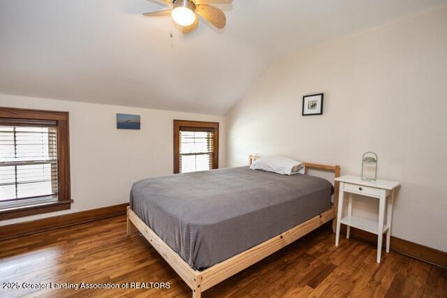 bedroom with baseboards, lofted ceiling, wood finished floors, and ceiling fan