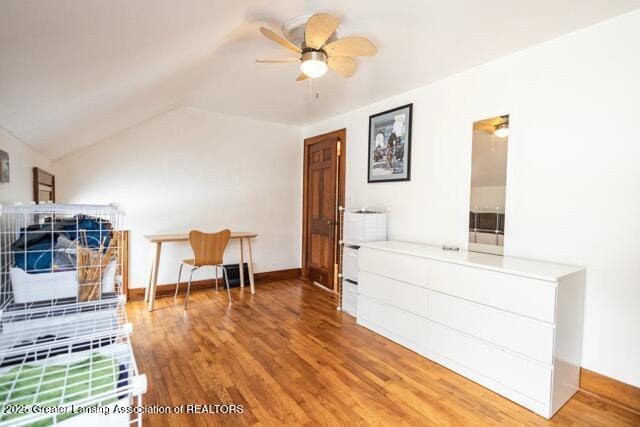bedroom featuring wood finished floors, lofted ceiling, baseboards, and ceiling fan