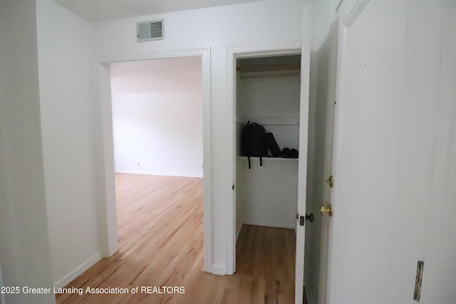 hall featuring light wood-style floors and baseboards
