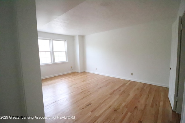 spare room with light wood-style flooring and baseboards
