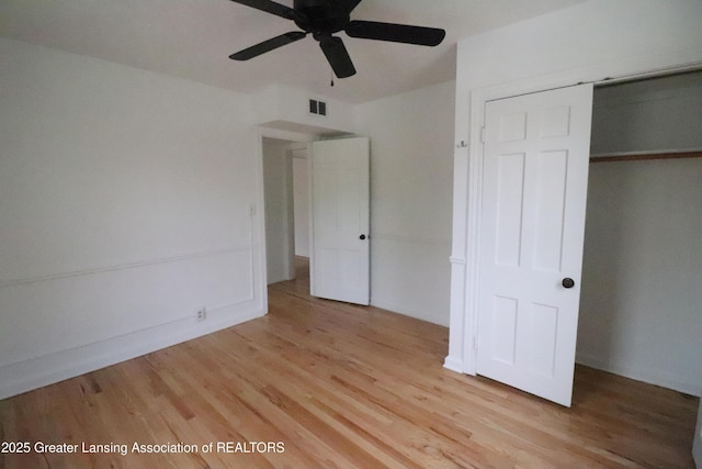 unfurnished bedroom featuring light wood-style flooring, a closet, and a ceiling fan