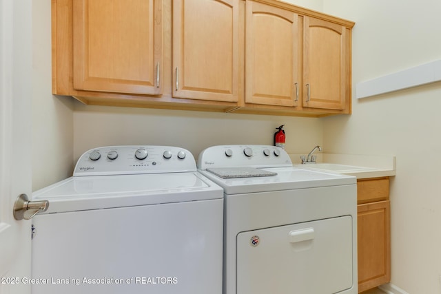 laundry room featuring independent washer and dryer and cabinet space