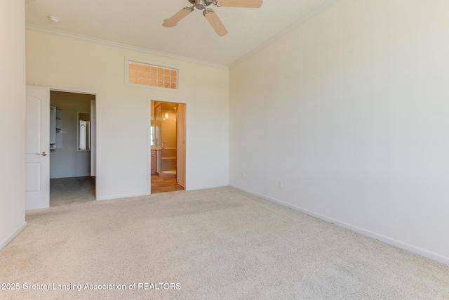 unfurnished bedroom featuring crown molding, carpet floors, baseboards, connected bathroom, and a ceiling fan