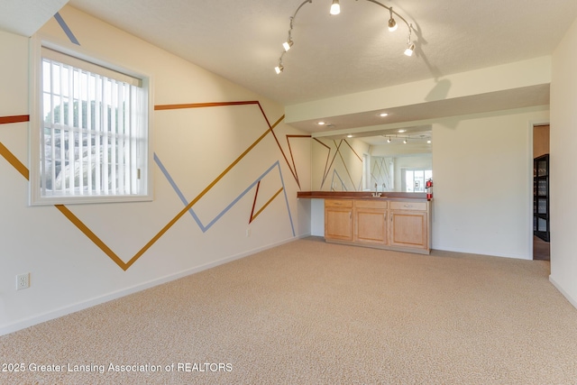 unfurnished room with light carpet, a sink, baseboards, and recessed lighting