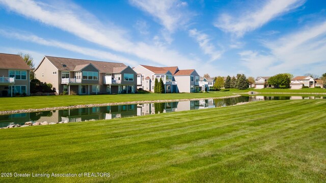 view of home's community featuring a water view, a residential view, and a yard