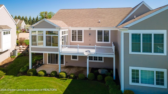 back of property featuring a patio, central AC, a yard, a sunroom, and roof with shingles