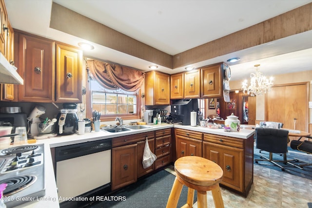 kitchen with white dishwasher, a sink, a peninsula, light countertops, and a chandelier