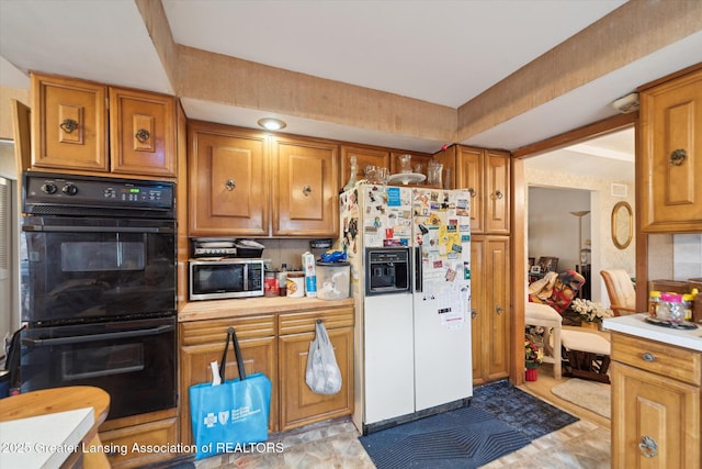 kitchen with stainless steel microwave, white fridge with ice dispenser, brown cabinetry, and light countertops