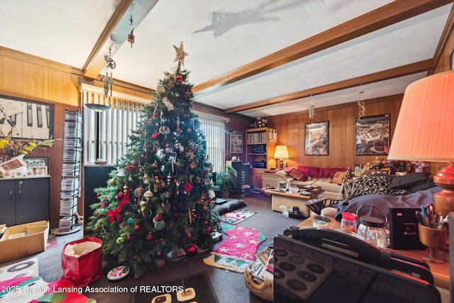 living area featuring wooden walls, beam ceiling, and carpet floors