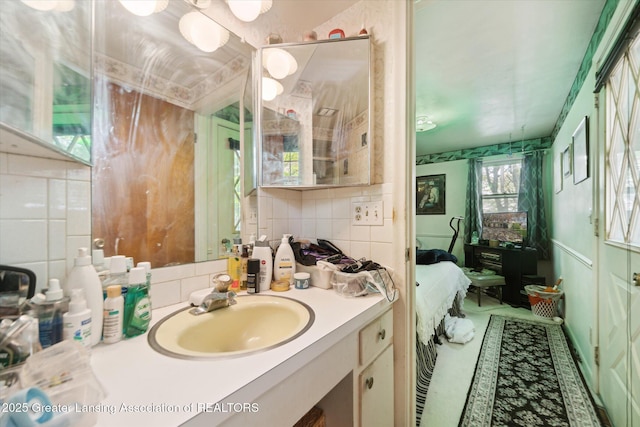 bathroom with ensuite bath, vanity, and decorative backsplash