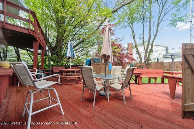 wooden deck featuring outdoor dining space and fence
