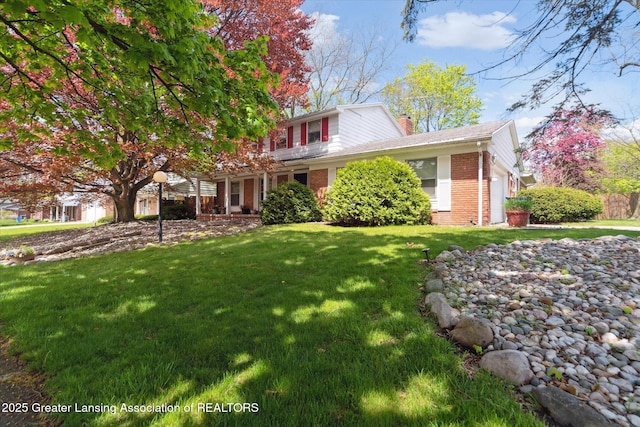 view of front of property featuring brick siding, a chimney, and a front lawn