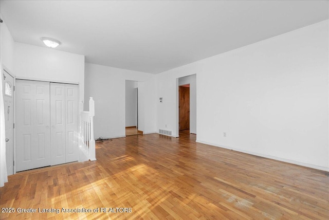 unfurnished bedroom with light wood-style floors, a closet, and baseboards