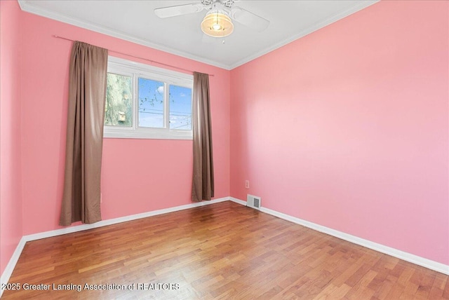 unfurnished room with wood finished floors, baseboards, ceiling fan, and crown molding