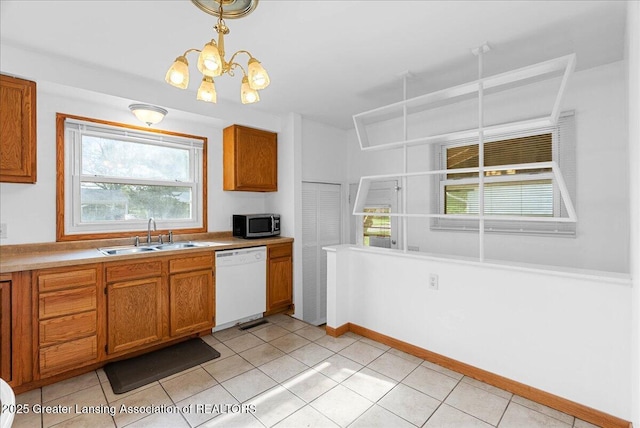 kitchen with dishwasher, a sink, stainless steel microwave, a chandelier, and brown cabinets